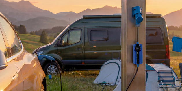 Camper van and car charging at a rural campsite power post at golden hour